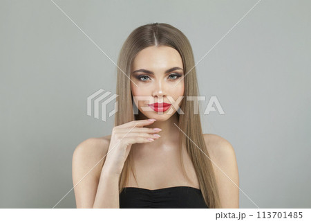 Beautiful young brunette female model with long brown wavy hair and makeup closeup portrait 113701485