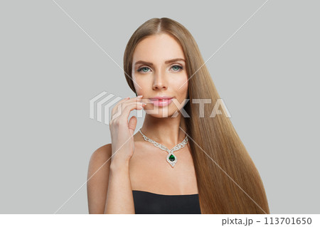 Smiling woman with makeup wearing jewelry necklace with sapphire and diamond on grey background 113701650