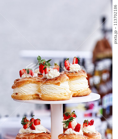 Yolk wreaths with cream and strawberries, closeup. 113702186