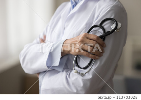 Closeup view unknown woman doctor in white coat holding stethoscope Closeup view unknown woman doctor in white coat holding stethoscope 113703028
