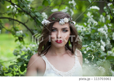 Portrait of healthy woman with fresh skin, make-up and brown wavy hair outdoor 113703061