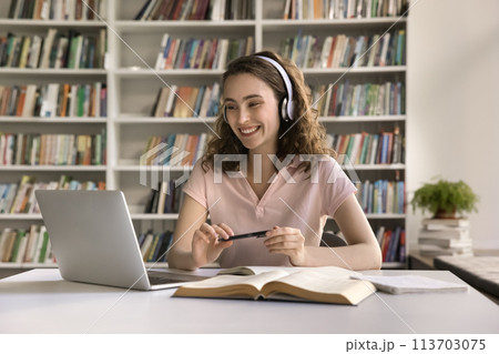 Happy girl in headphones engaged in on-line class 113703075