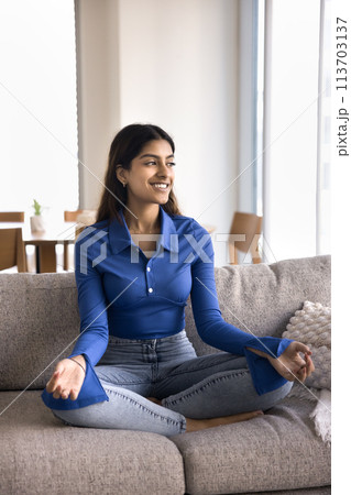 Positive beautiful young 20s Indian girl sitting in meditation pose Positive beautiful young 20s Indian girl sitting in meditation pose 113703137