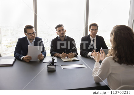 Female applicant sitting at desk in front of HR managers 113703233