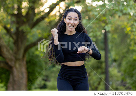 Vibrant image of a joyful Hispanic woman running in a park, expressing vitality and happiness. Perfect capture of active lifestyle and fitness enthusiasm. Vibrant image of a joyful Hispanic woman running in a park, expressing vitality and happiness. Perfect capture of active lifestyle and fitness enthusiasm. 113703470