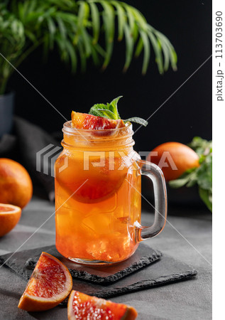 Freshly squeezed blood orange juice with ice, mint and a slice of fruit in a jar Freshly squeezed blood orange juice with ice, mint and a slice of fruit in a jar 113703690