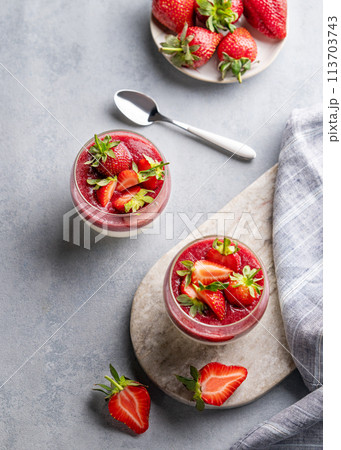 Strawberry and cream panna cotta in glasses with fresh berries on a marble board Strawberry and cream panna cotta in glasses with fresh berries on a marble board 113703743