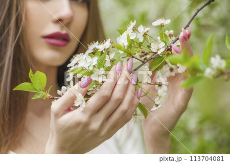 Spring flowers in female hands closeup against floral background outdoor Spring flowers in female hands closeup against floral background outdoor 113704081