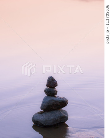 Stones (pebbles) stacked on top of each other - rockbalance. Gentle sunset colors. Stones (pebbles) stacked on top of each other - rockbalance. Gentle sunset colors. 113705636