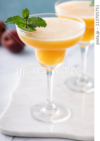 Frozen peach margaritas in three glasses with mint Frozen peach margaritas in three glasses with mint 113705751