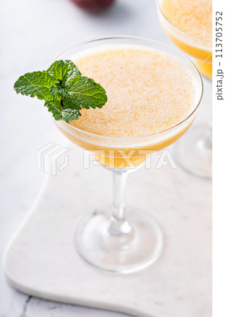 Frozen peach margaritas in three glasses with mint 113705752