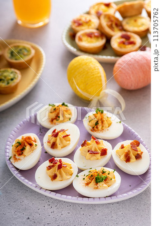 Deviled eggs and mini quiches, appetizers for Easter 113705762