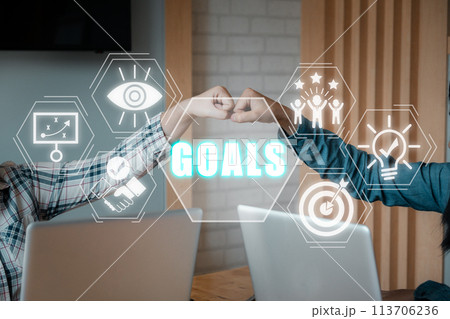 Goals concept, Young business people pump hands on office workspace with vision, plan, support, success, innovation and goals icon on virtual screen. 113706236