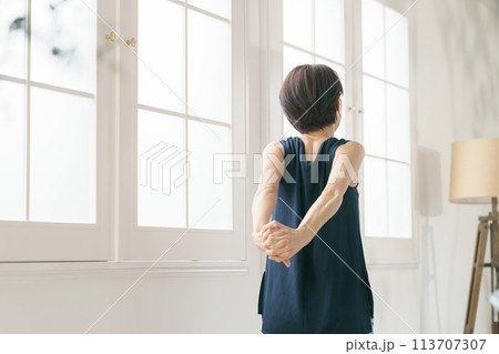 窓際でストレッチをする30代女性 窓際でストレッチをする30代女性 113707307