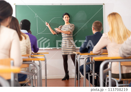 Asian female teacher lecturing to adult students in auditorium 113708219