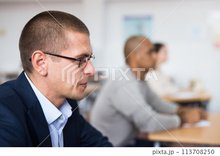 Focused man studying at adult education class Focused man studying at adult education class 113708250