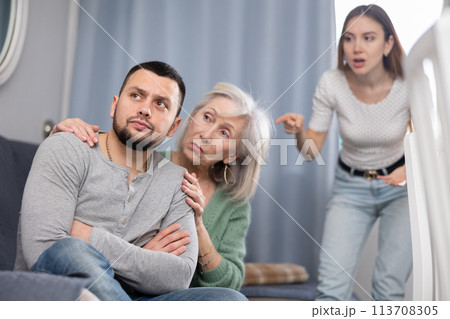 Elderly mother comforts her son after his quarrel with his wife Elderly mother comforts her son after his quarrel with his wife 113708305
