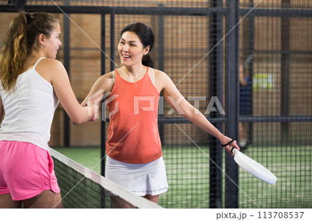 Woman padel player shaking hands to female opponent after match Woman padel player shaking hands to female opponent after match 113708537