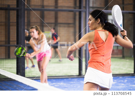 Young asian woman playing padel on a hard court Young asian woman playing padel on a hard court 113708545