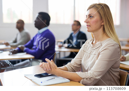 Portrait of woman in group of students in university audience 113708609