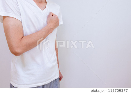 胸に拳を当てる男性 113709377