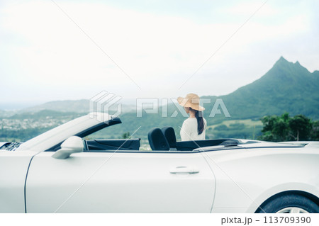 見晴らしのいい丘に停めたオープンカー海に乗り込む女性 見晴らしのいい丘に停めたオープンカー海に乗り込む女性 113709390