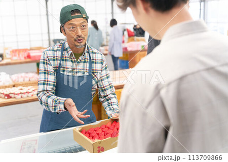 店頭で苺を販売する男性スタッフ 113709866