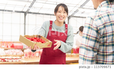 笑顔でお客と話す若い女性販売スタッフ 113709871