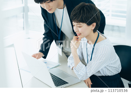 オフイスでパソコン操作をする若い男女 113710536