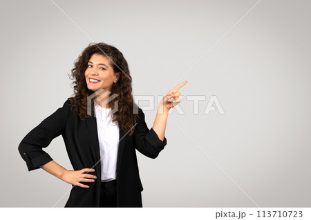 Smiling woman pointing to the side Smiling woman pointing to the side 113710723