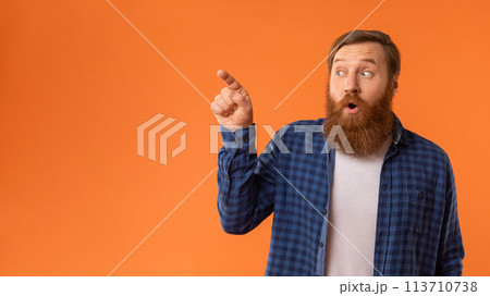 Amazed Redhaired Man Pointing Finger Aside At Empty Space, Studio Amazed Redhaired Man Pointing Finger Aside At Empty Space, Studio 113710738
