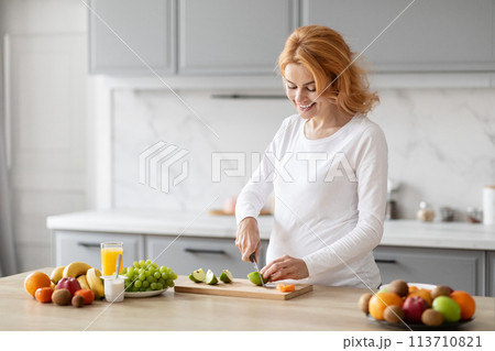 Pregnant woman preparing food in kitchen, copy space Pregnant woman preparing food in kitchen, copy space 113710821