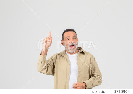 Excited senior pointing upwards on white background Excited senior pointing upwards on white background 113710909