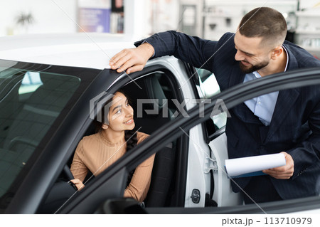Salesman explaining car features to a woman 113710979