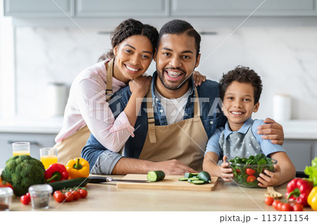 Family portrait of black parents cooking with their son 113711154