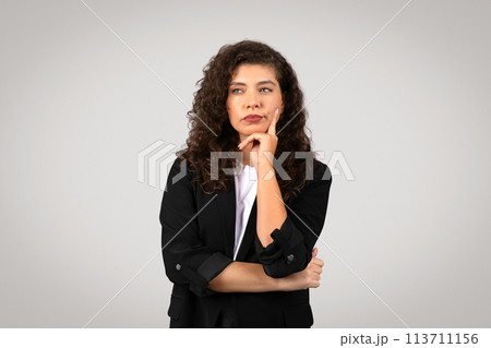 Thoughtful businesswoman with chin on hand 113711156