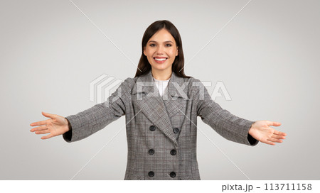 Welcoming businesswoman with arms outstretched smiling at camera Welcoming businesswoman with arms outstretched smiling at camera 113711158