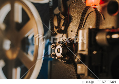 Vintage 8mm film projector, rotating reels. Nostalgic charm of classic cinema. 113711364
