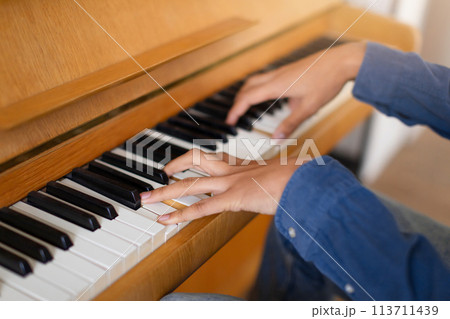 Practicing piano, focused on the keys 113711439