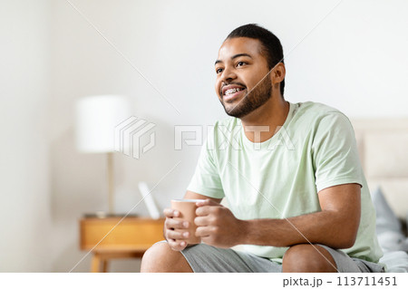 Smiling black man enjoying morning at home Smiling black man enjoying morning at home 113711451