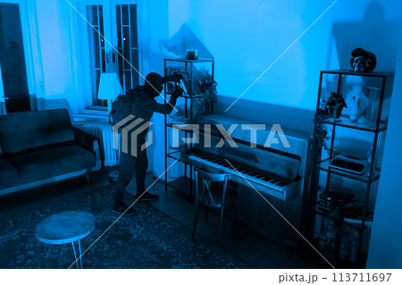 Burglar sneaking in a room with a piano 113711697