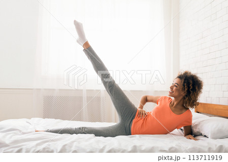 Girl exercising in bed in the morning 113711919