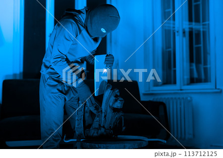 Masked man criminal preparing tools for burglary Masked man criminal preparing tools for burglary 113712125