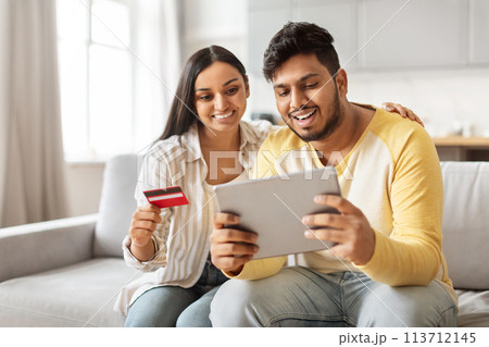 Indian couple shopping online with tablet at home Indian couple shopping online with tablet at home 113712145