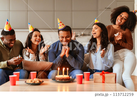 Group of friends gathered around birthday cake 113712259
