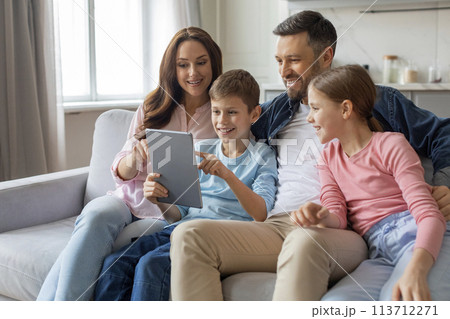 Family gathered around a digital tablet, home interior 113712271