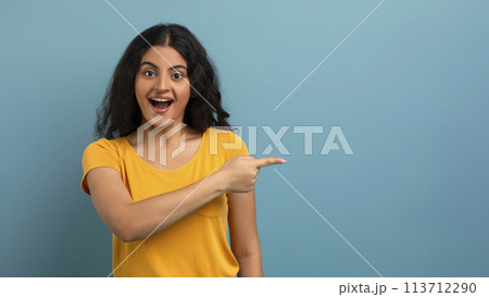 Excited woman pointing outside of frame 113712290