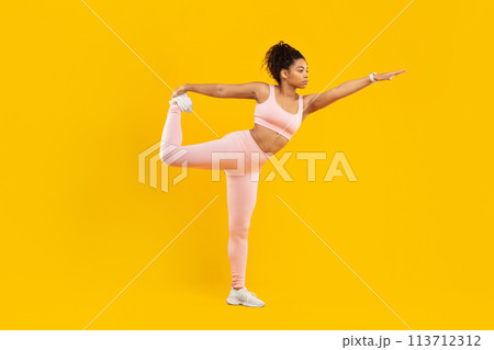 Black lady doing a yoga pose on yellow background 113712312