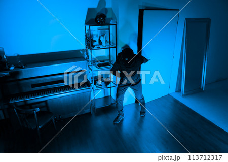 Thief with crowbar breaking into secured house 113712317