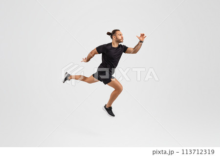 Man running in mid-air on white background 113712319